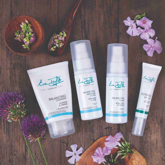 Set of skincare products with floral elements on a wooden background