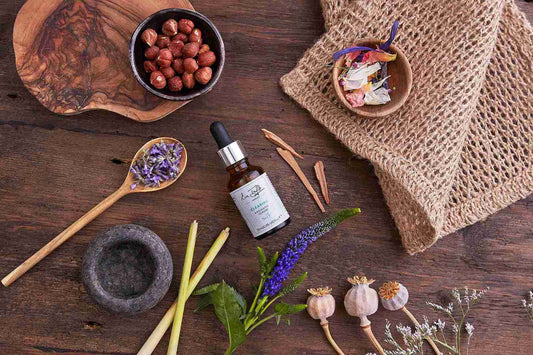 Herbal and natural products on a wooden surface with a bottle of tincture.