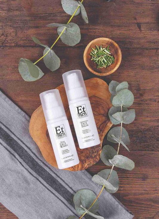 Two bottles of Et men on a wooden board with eucalyptus leaves on a wooden surface