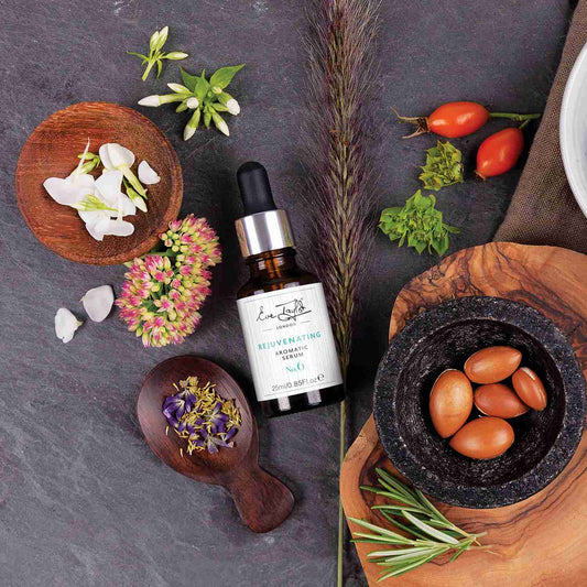 Bottle of skincare product surrounded by natural elements on a dark surface