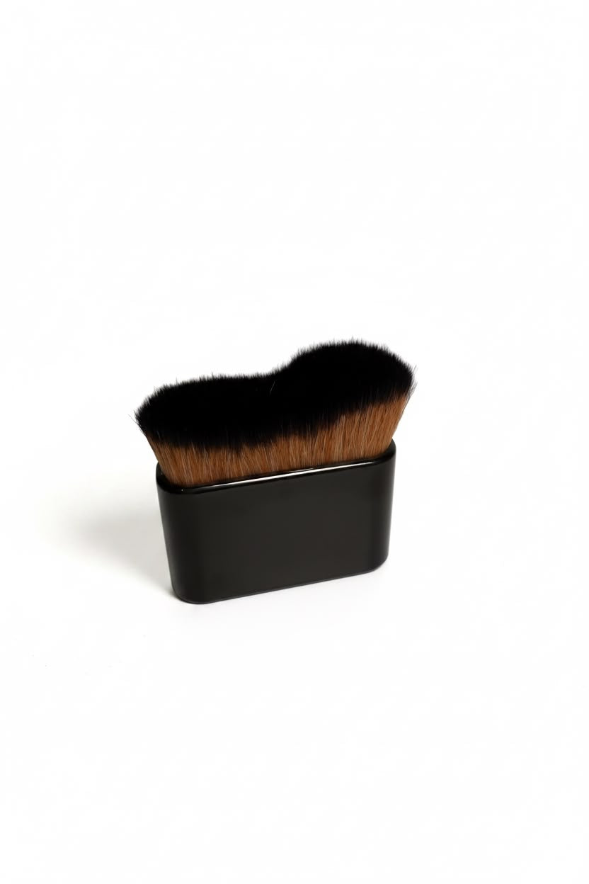 Tanning brush with dense black bristles and a dark square handle