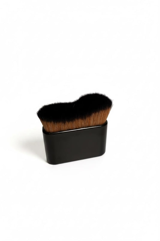 Tanning brush with dense black bristles and a dark square handle