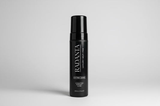 Extra dark tanning mousse bottle with black pump cap and vertical label