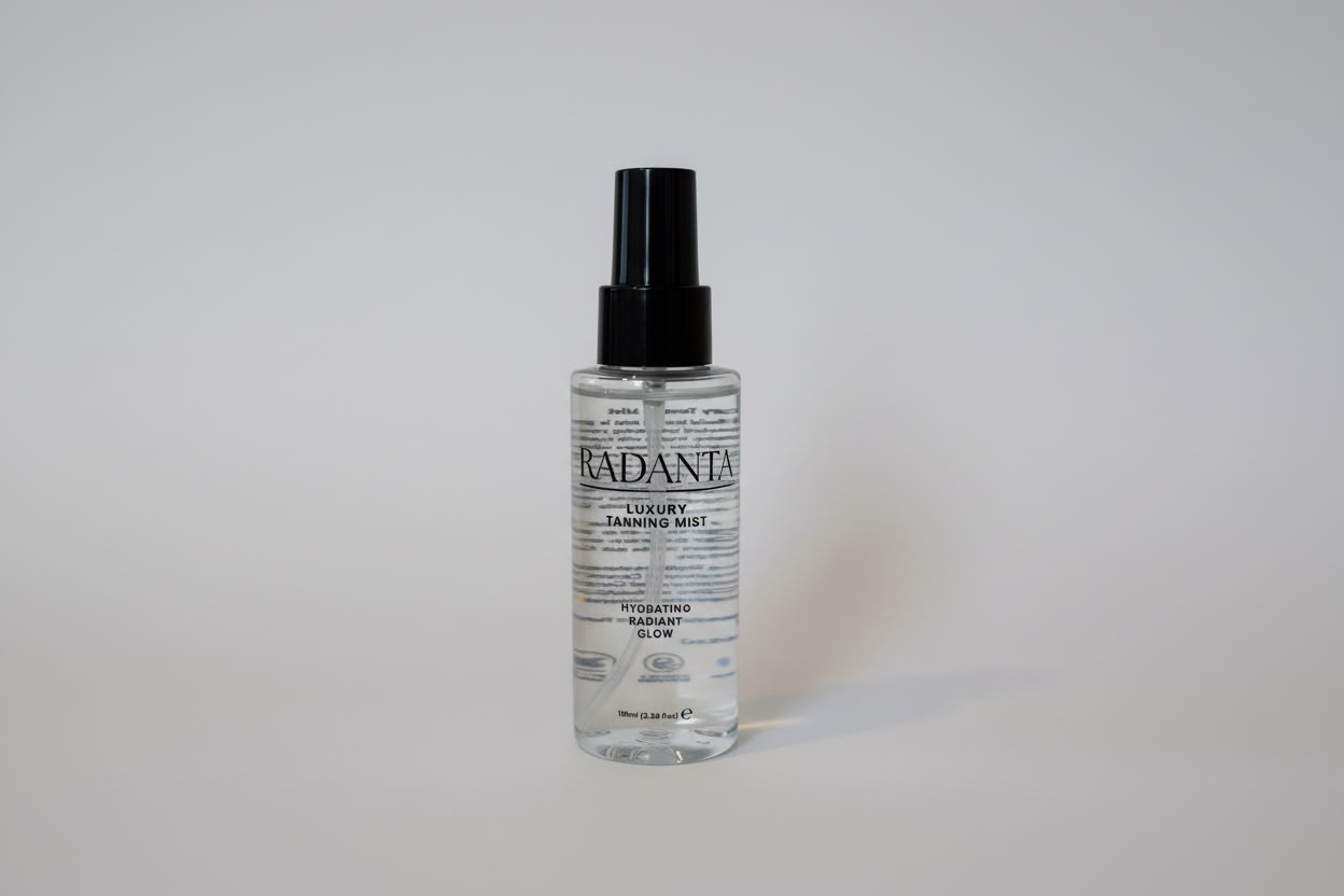 Tanning mist bottle with clear liquid and black spray pump dispenser