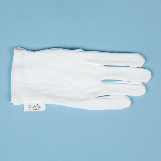 White cotton moisture gloves laid flat with thumb and finger sections