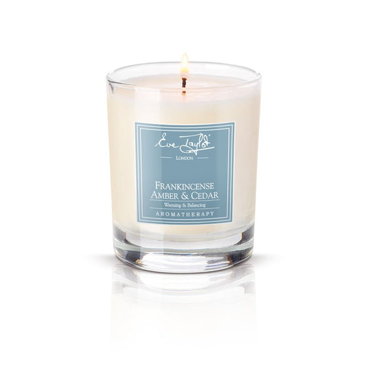 Frankincense amber and cedar massage candle in clear glass jar with cream wax and label
