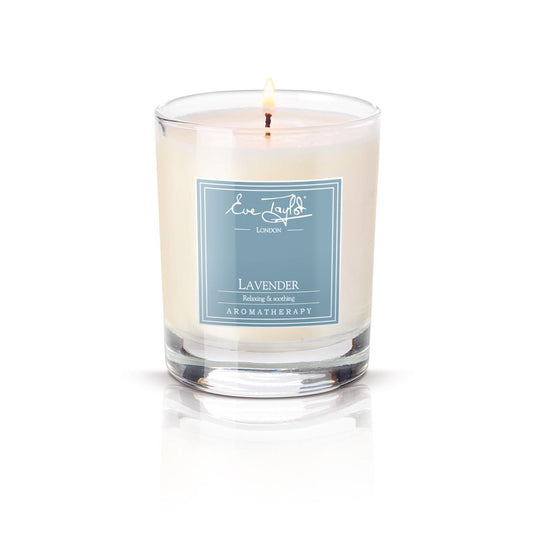 Lavender massage candle in clear glass jar, lit wick, lavender aromatherapy label.