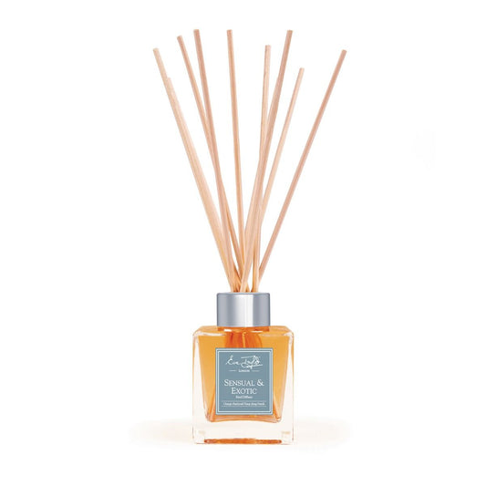 Natural reed diffuser with orange glass bottle and bundled light wood reeds